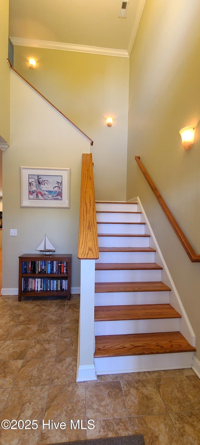 staircase with baseboards, visible vents, and crown molding