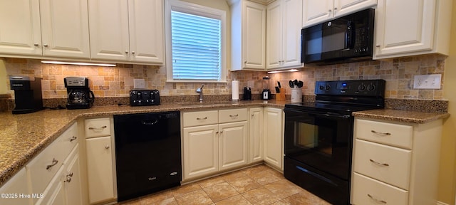 kitchen featuring light stone counters, white cabinets, a sink, and black appliances