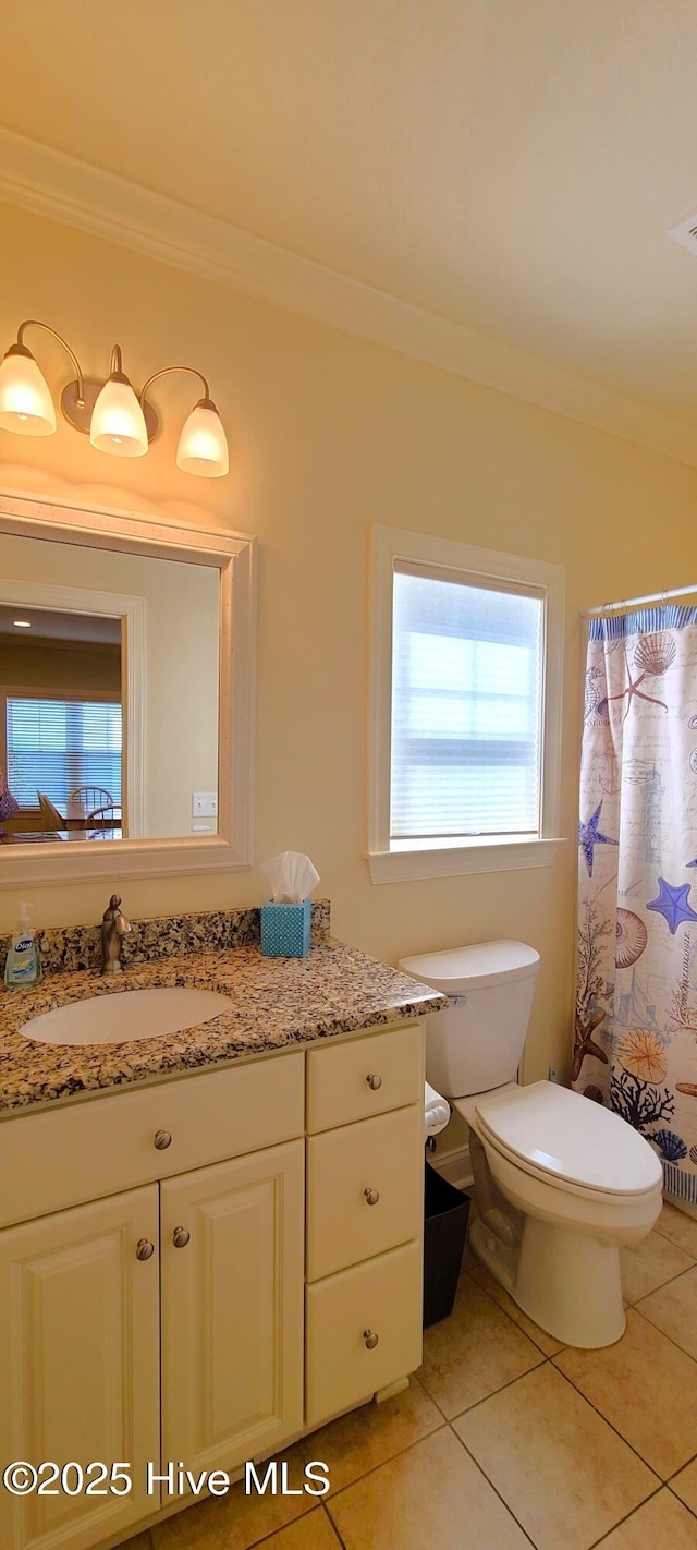bathroom with ornamental molding, vanity, toilet, and tile patterned floors