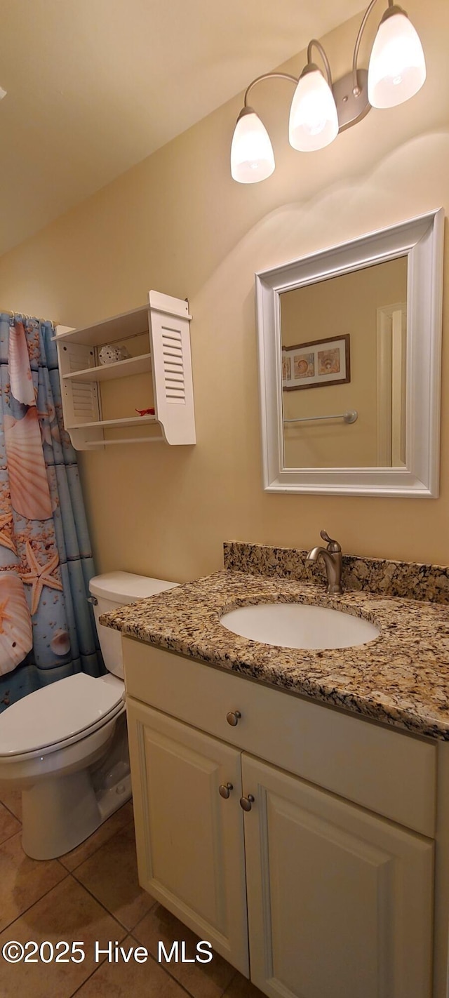 bathroom with toilet, tile patterned flooring, and vanity