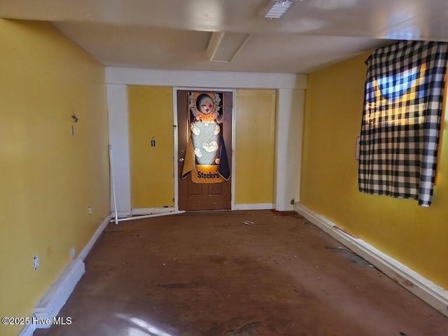 interior space with concrete flooring and baseboards