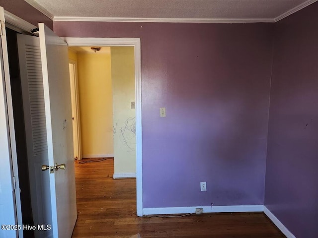 spare room featuring ornamental molding, wood finished floors, and baseboards