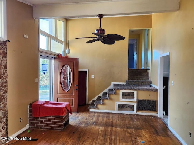 foyer entrance with stairs, dark wood-type flooring, a wealth of natural light, and baseboards