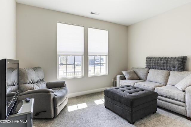 living area featuring carpet floors, visible vents, and baseboards