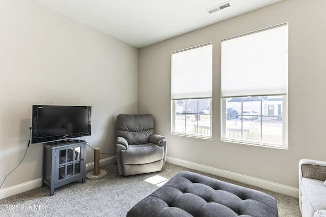 living area with carpet floors, visible vents, and baseboards