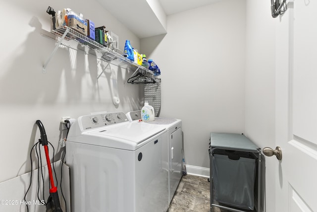 washroom with laundry area, washer and clothes dryer, and baseboards