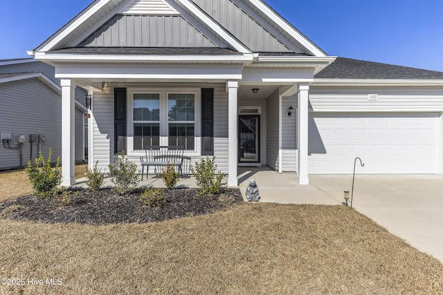 view of front of home with roof with shingles, covered porch, an attached garage, board and batten siding, and driveway