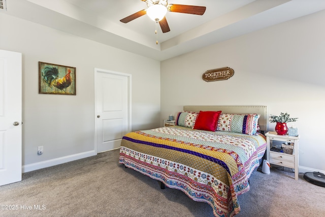 carpeted bedroom with ceiling fan, a raised ceiling, visible vents, and baseboards