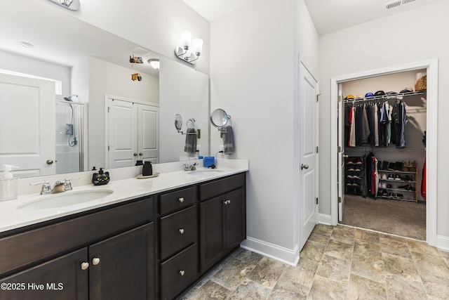 bathroom featuring double vanity, a sink, and baseboards