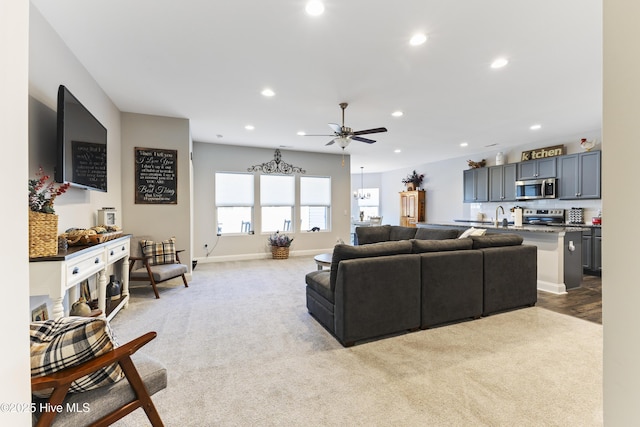 living room featuring ceiling fan, baseboards, light colored carpet, and recessed lighting