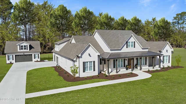 modern inspired farmhouse with a garage, covered porch, a front lawn, and a standing seam roof