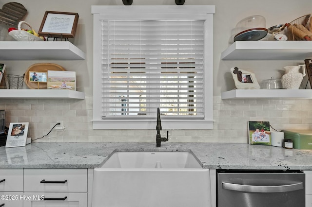 kitchen with a sink, white cabinetry, light stone countertops, dishwasher, and open shelves