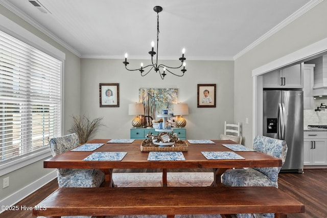 dining area featuring dark wood-style floors, an inviting chandelier, visible vents, and crown molding