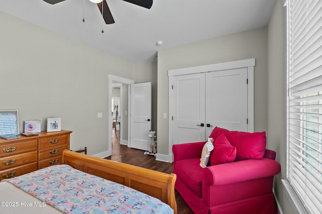 bedroom with dark wood-style floors, a closet, a ceiling fan, and baseboards