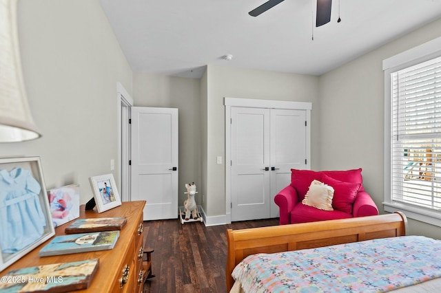 bedroom with ceiling fan, dark wood-style flooring, a closet, and baseboards