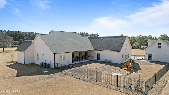 exterior space featuring central AC, a patio, a playground, and a fenced backyard