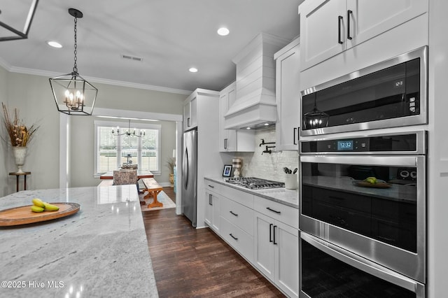 kitchen with stainless steel appliances, light stone counters, and white cabinetry