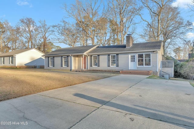 single story home with a front yard and a chimney