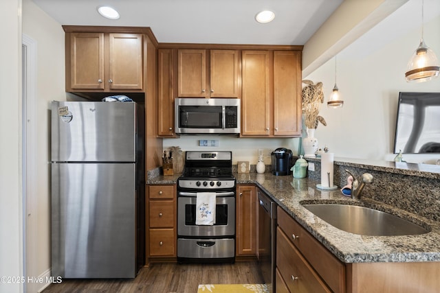 886 New River Inlet Rd Unit 41, North Topsail Beach, NC 28460 - kitchen featuring stainless steel appliances, a sink, a peninsula, brown cabinetry, and dark stone counters