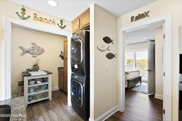 886 New River Inlet Rd Unit 41, North Topsail Beach, NC 28460 - laundry room featuring stacked washer / drying machine, cabinet space, dark wood-style flooring, and baseboards