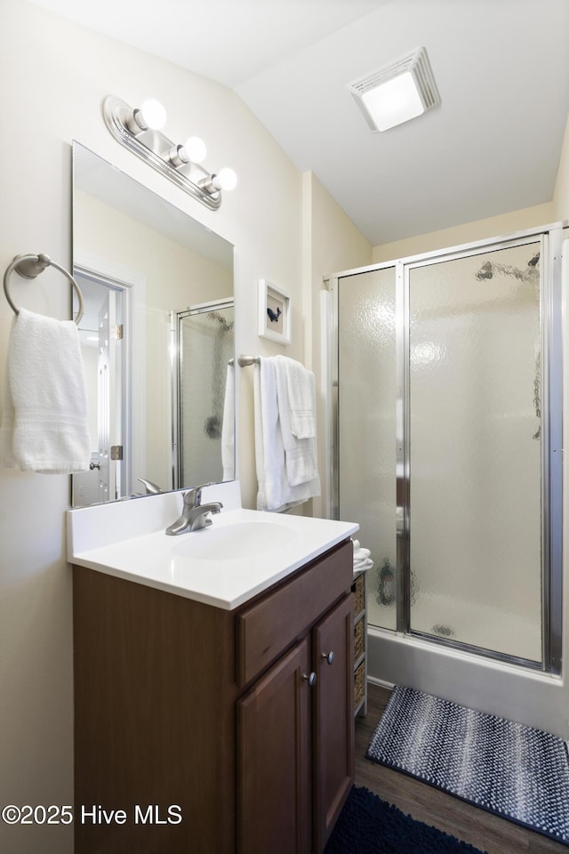 886 New River Inlet Rd Unit 41, North Topsail Beach, NC 28460 - full bathroom with vanity, a shower with door, wood finished floors, and vaulted ceiling