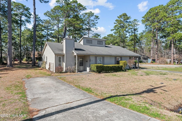 view of front of property featuring a chimney and a front yard