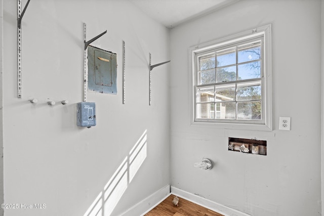 clothes washing area featuring hookup for a washing machine, gas dryer hookup, wood finished floors, laundry area, and baseboards