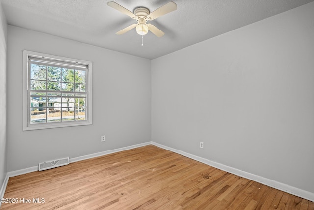 unfurnished room featuring light wood-style floors, baseboards, visible vents, and a ceiling fan