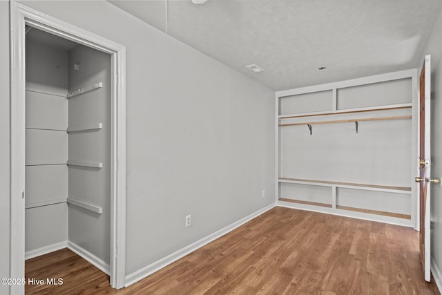 unfurnished bedroom with a closet, baseboards, and wood finished floors