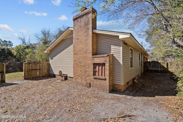 view of property exterior with fence and a chimney