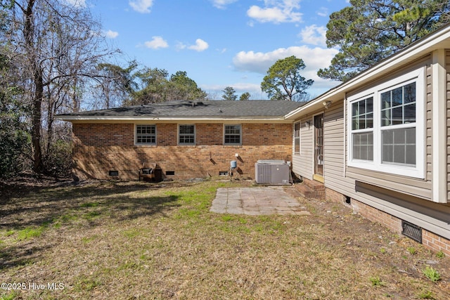 back of house with crawl space, a patio area, cooling unit, and brick siding