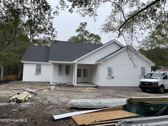 back of house with a shingled roof and board and batten siding