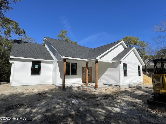 modern inspired farmhouse with french doors, board and batten siding, and roof with shingles