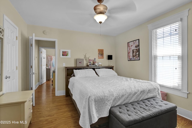 bedroom featuring ceiling fan, baseboards, and wood finished floors