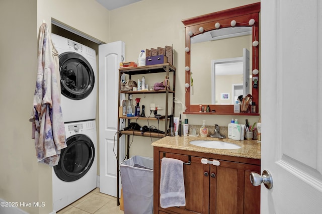 clothes washing area featuring a sink, stacked washer and clothes dryer, laundry area, and light tile patterned floors