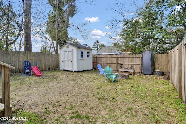 view of yard with an outbuilding, a fenced backyard, and a shed