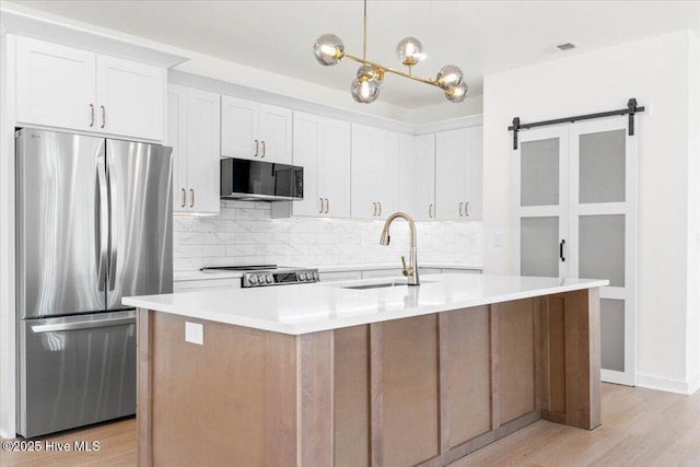 1708 Oakbrook Dr SW, Ocean Isle Beach, NC 28469 - kitchen with freestanding refrigerator, black microwave, tasteful backsplash, and light wood-style floors