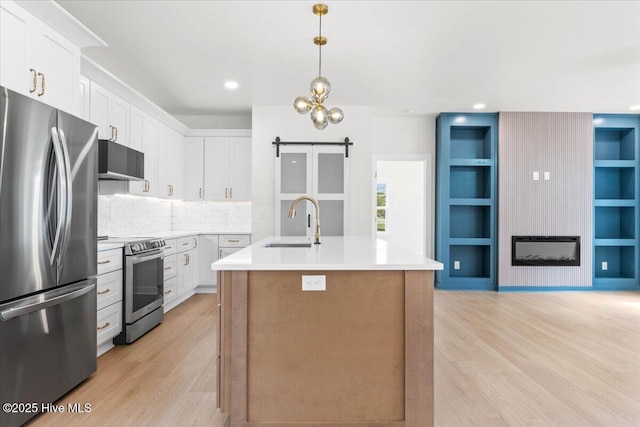 1708 Oakbrook Dr SW, Ocean Isle Beach, NC 28469 - kitchen with appliances with stainless steel finishes, light wood-style flooring, white cabinets, a center island with sink, and recessed lighting