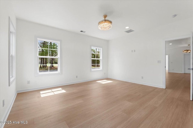 1708 Oakbrook Dr SW, Ocean Isle Beach, NC 28469 - spare room with a chandelier, light wood-style floors, and a smoke detector