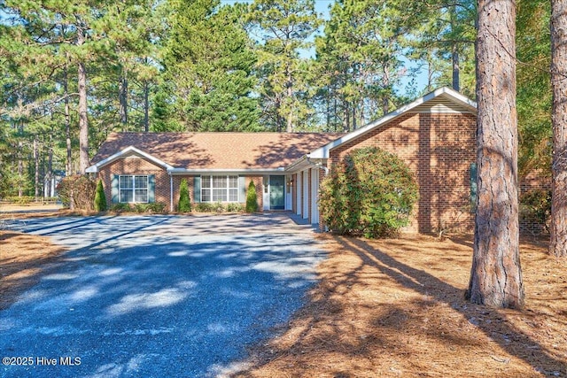 view of front facade featuring brick siding and driveway