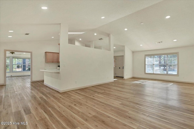 unfurnished living room with light wood finished floors, baseboards, and visible vents