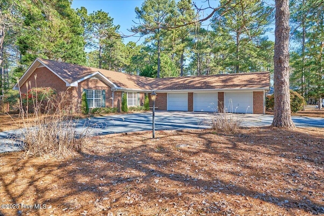 ranch-style house featuring concrete driveway and brick siding