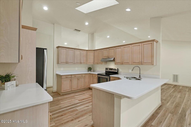 kitchen featuring light brown cabinets, under cabinet range hood, a sink, visible vents, and appliances with stainless steel finishes