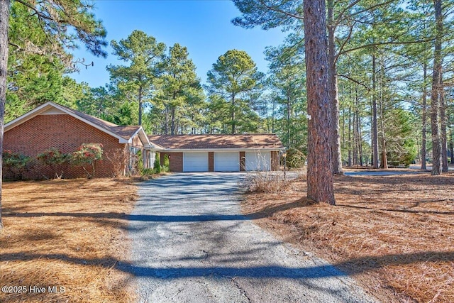 view of front of home with brick siding, driveway, and an attached garage