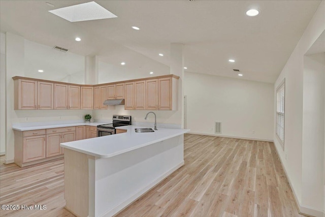 kitchen with visible vents, stainless steel electric range oven, light brown cabinetry, under cabinet range hood, and a sink