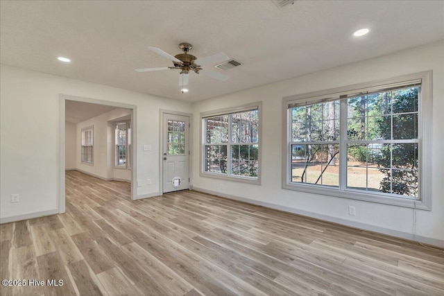 unfurnished room with light wood-style floors, recessed lighting, visible vents, and baseboards