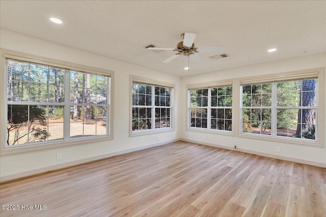 unfurnished sunroom with ceiling fan and visible vents