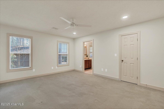 unfurnished bedroom with baseboards, multiple windows, and light colored carpet