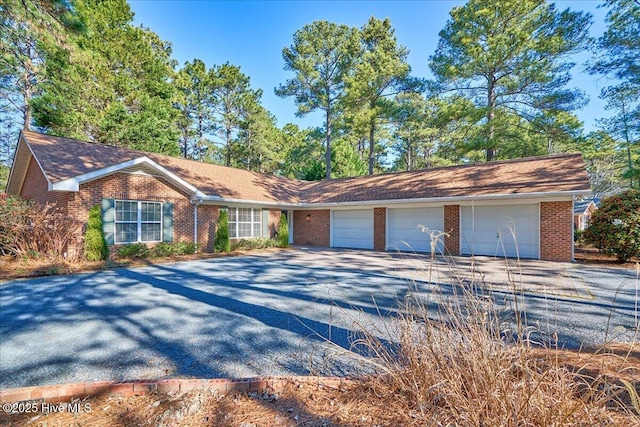 ranch-style house with brick siding, driveway, and an attached garage