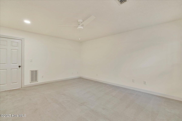 empty room featuring visible vents, ceiling fan, light carpet, and baseboards